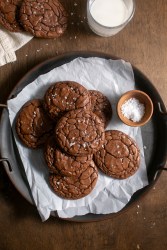 Brownie cookies stacked on a metal tray.