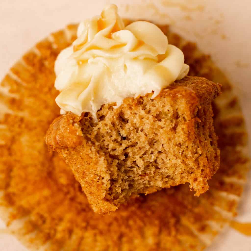 A bite shot of the carrot cake to show the texture and the chopped carrots inside.