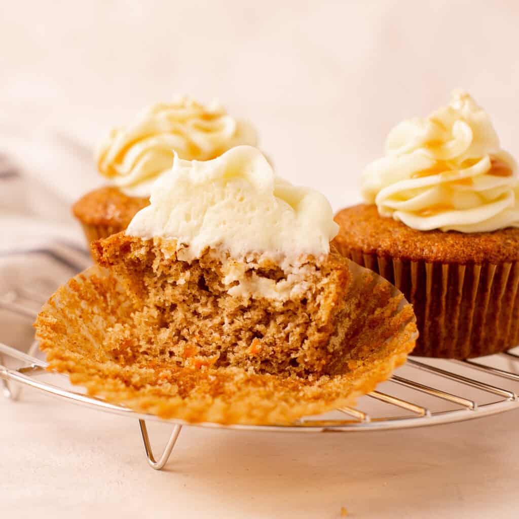 A carrot cake cupcake cut in half to show the inside. 