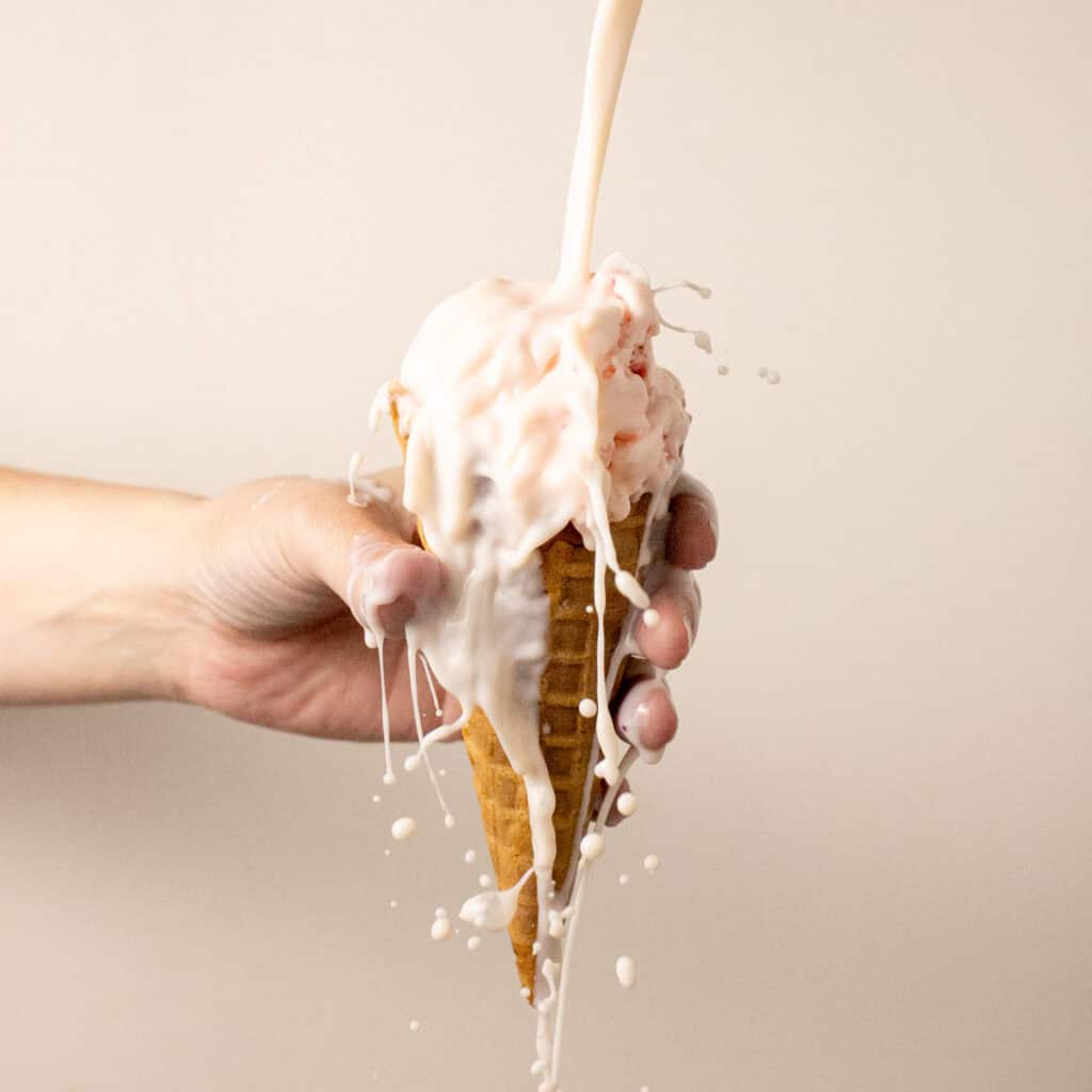 a pour shot of the liqueur falling on the ice cream cone 