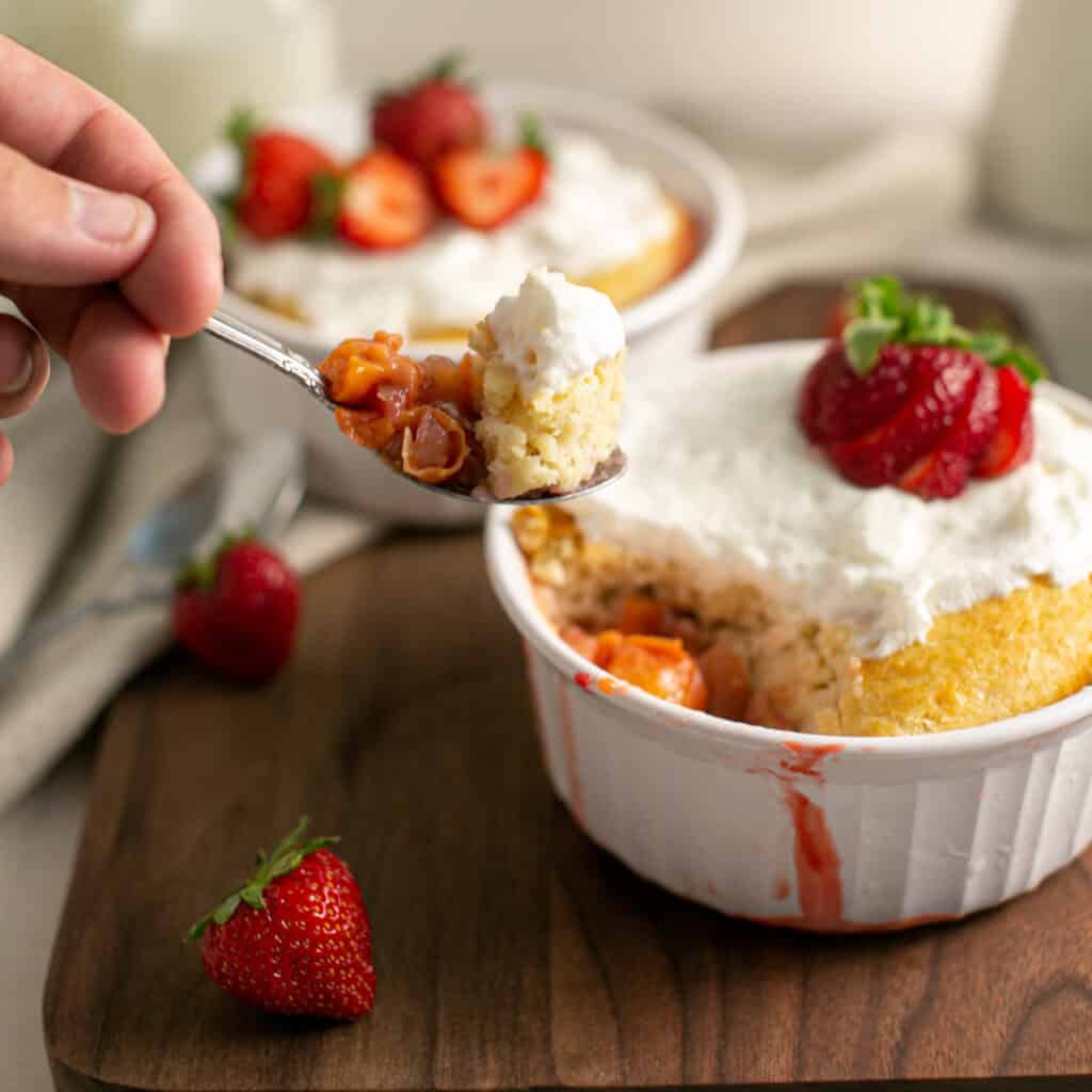 A picture of a spoon with a bite of the strawberry and peach cobbler on it.