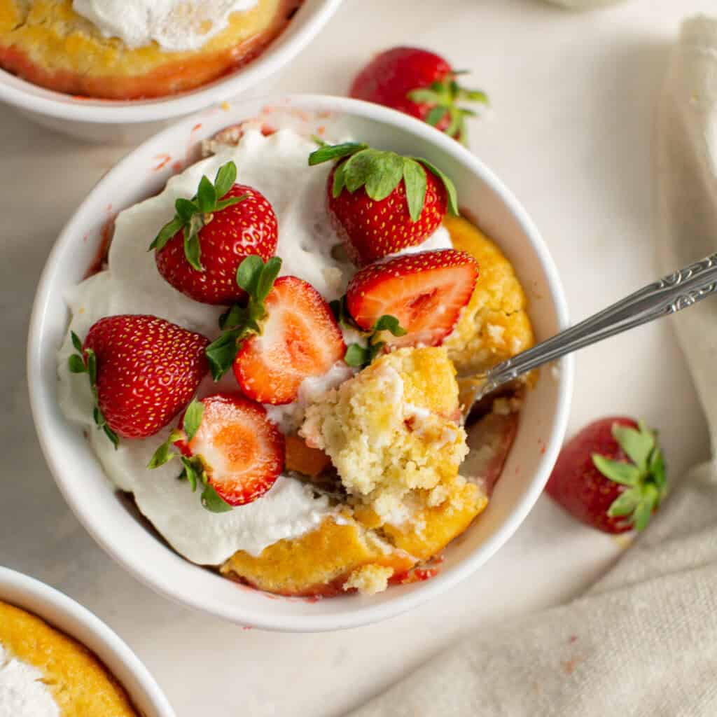 A picture of the strawberry and peach cobbler with a spoon resting inside 