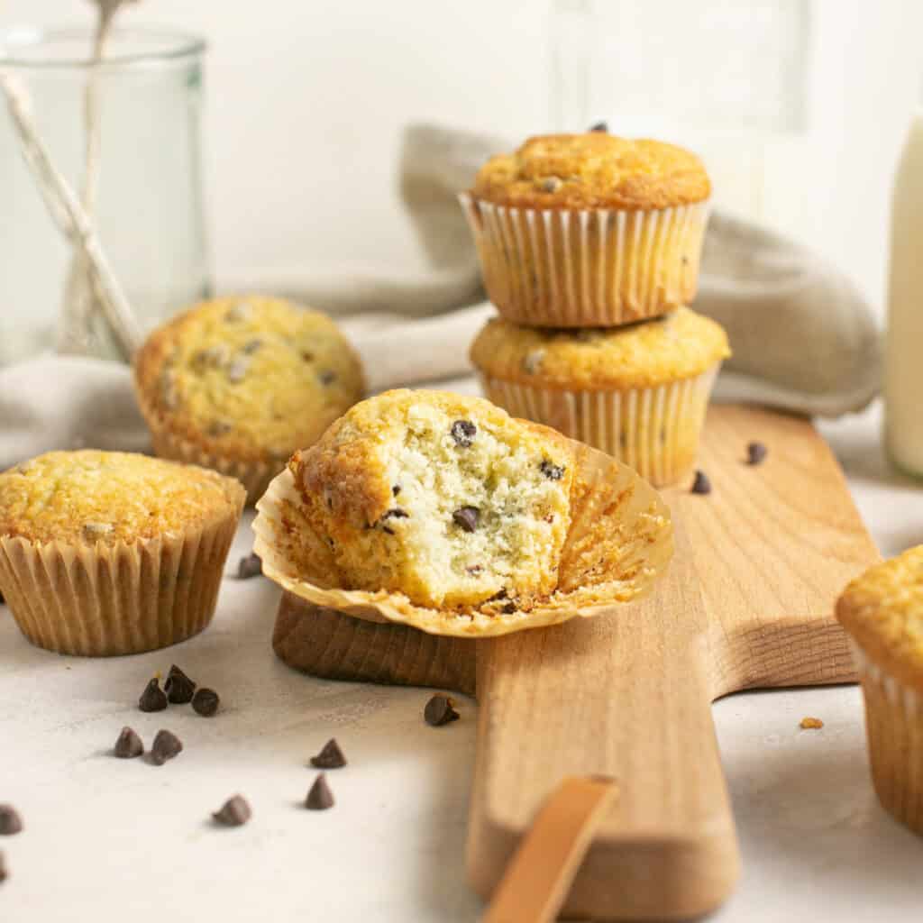 stacked chocolate chip muffins with a single bite taken out of one muffin