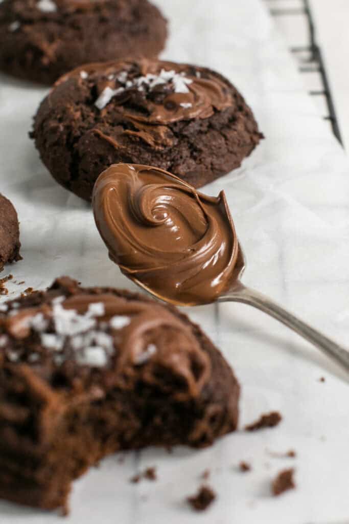A picture of the Nutella spread on a spoon sitting around the Nutella Swirl Cookies.