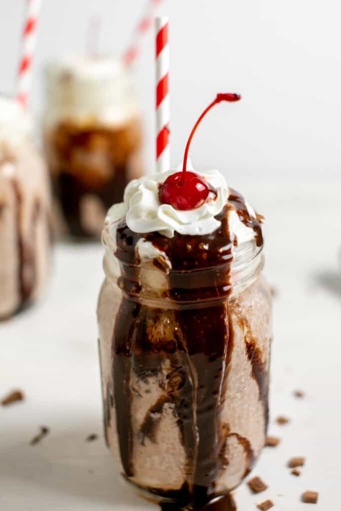 A close up of the cherry on top of the whipped cream in the Nutella Milkshake