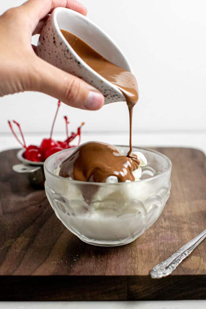 The warm chocolate magic sauce being poured over ice cream.