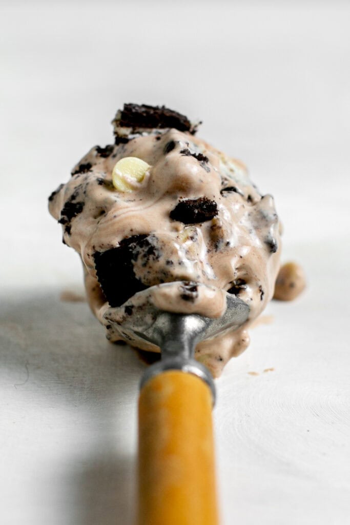 A close up shot of the chocolate cookies n cream ice cream in the ice cream scoop.