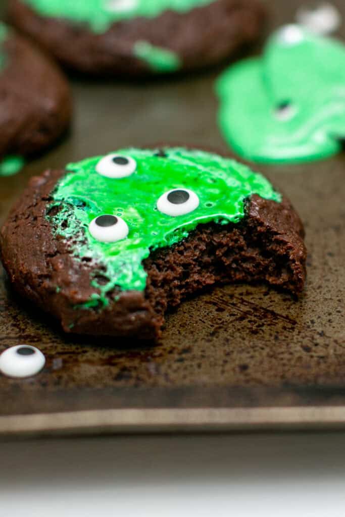 The gooey monster marshmallow cookie sitting on a sheet pan with a bite taken out of it. 