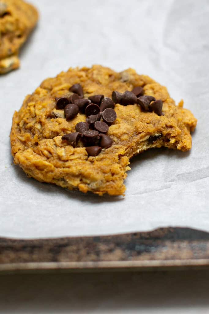 A pumpkin oatmeal cookie sitting on baking sheet. 