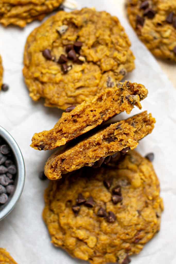 A pumpkin oatmeal cookie broken in half to show the soft, chewy insides.