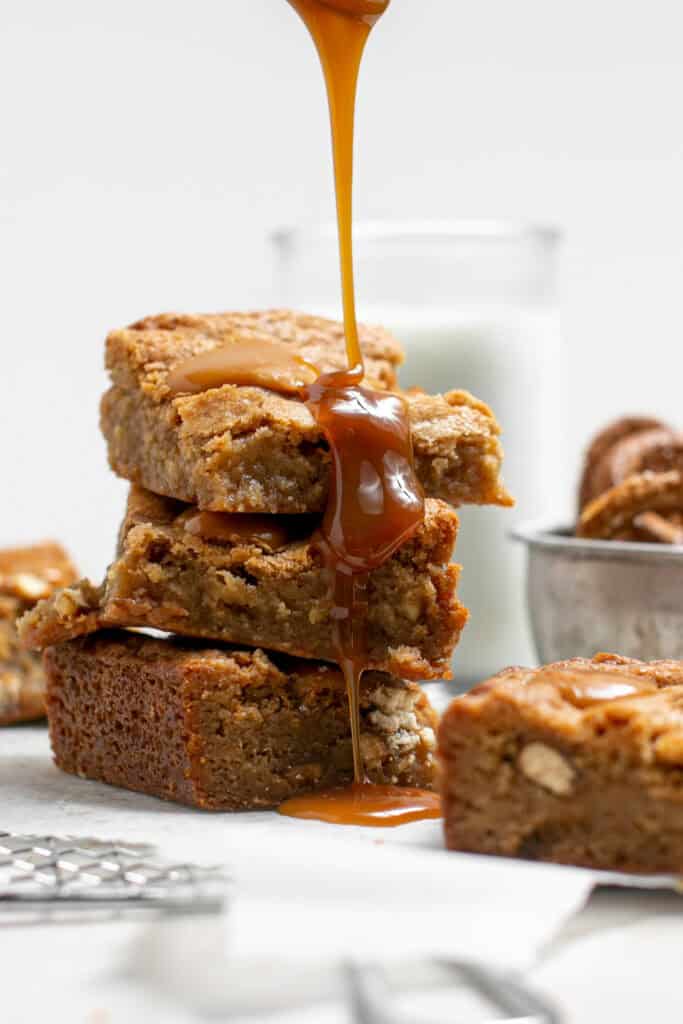 caramel being drizzled onto the salted caramel pretzel blondies