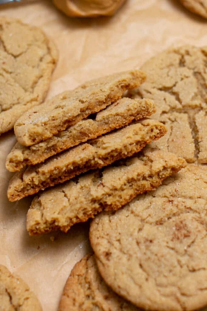 peanut butter snickerdoodle cookies broken in half stacked on top of each other 
