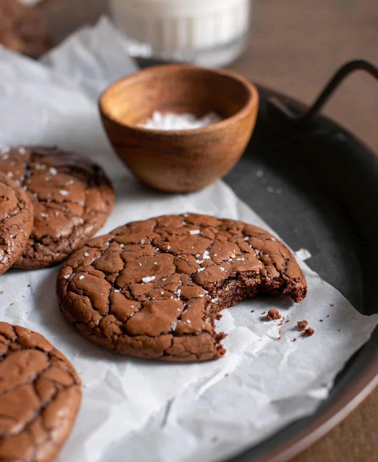 Brownie cookies with a bite missing on parchment paper
