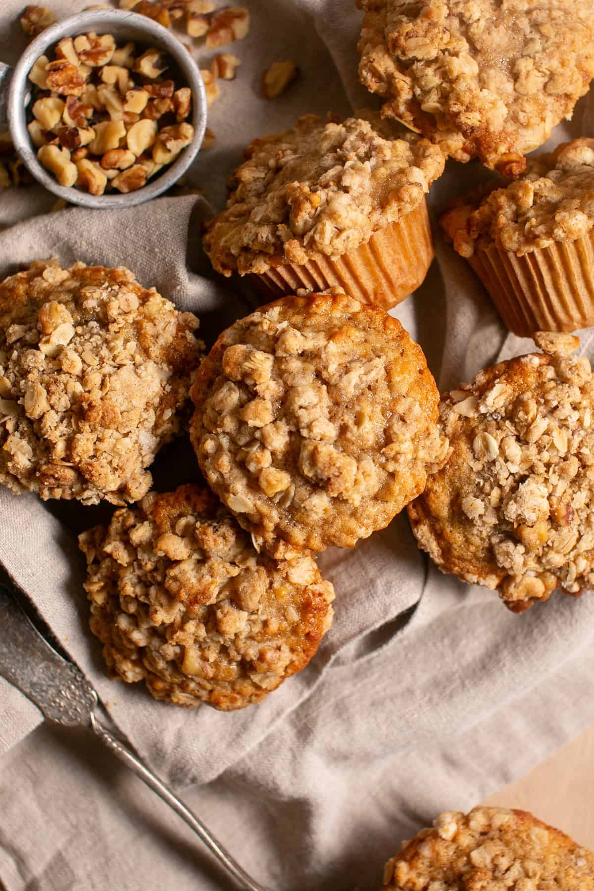 Banana Nut Muffins sitting by a bowl of walnuts.