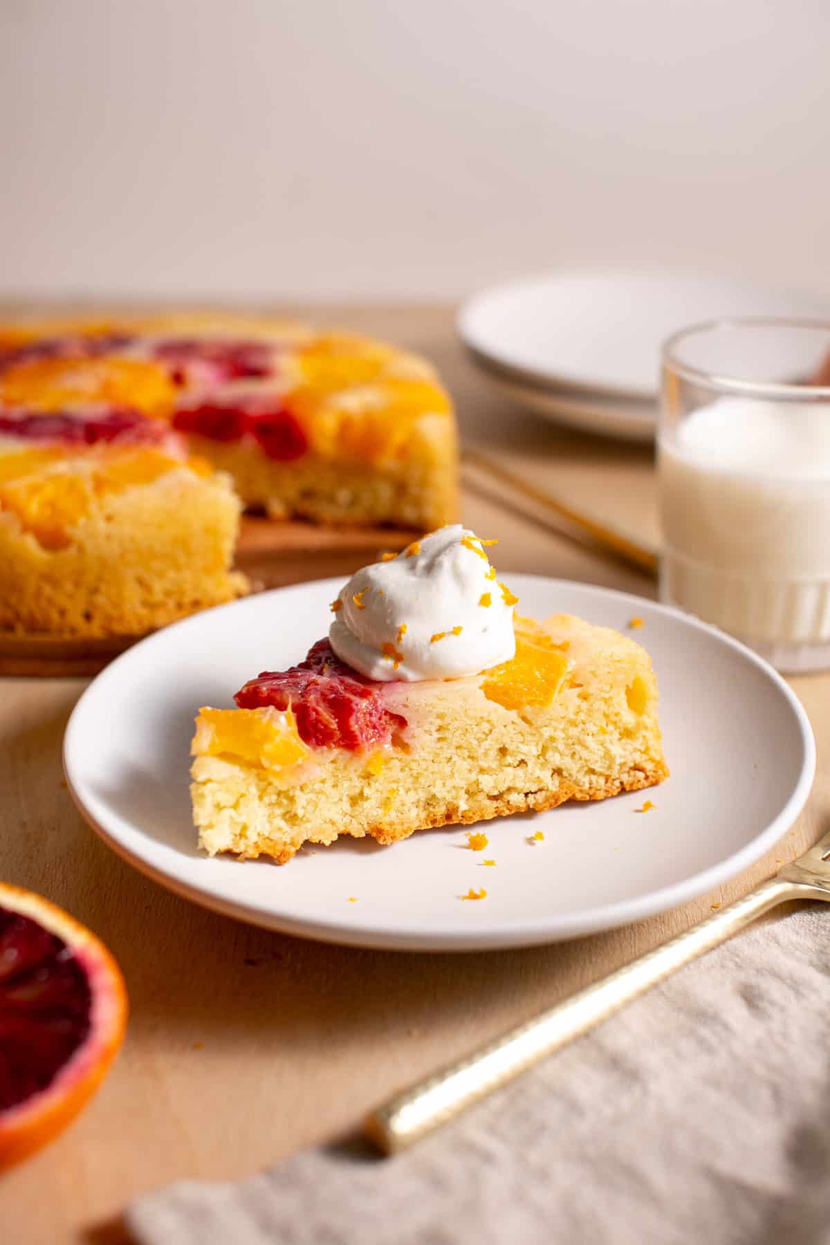 A slice of winter citrus cake with a dollop of whipped cream.