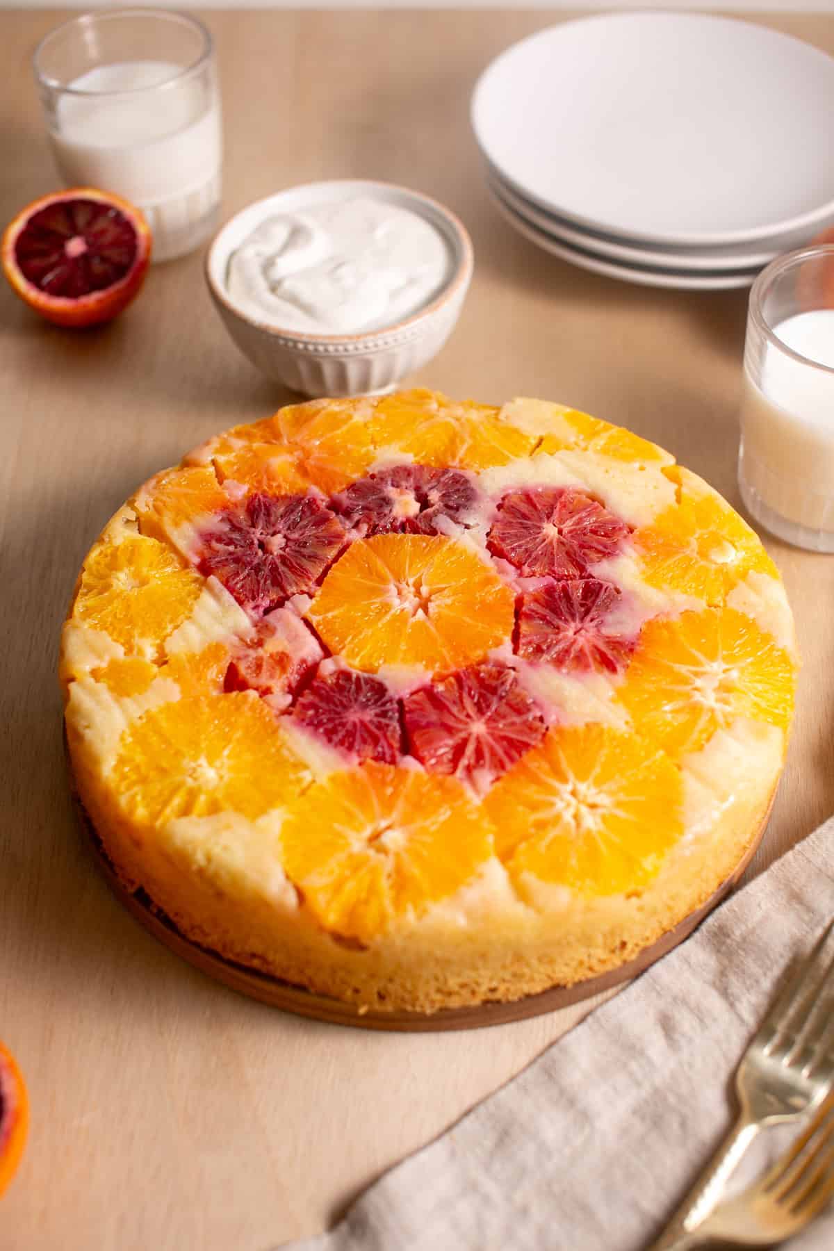 Winter Citrus cake on a wooden cutting board.