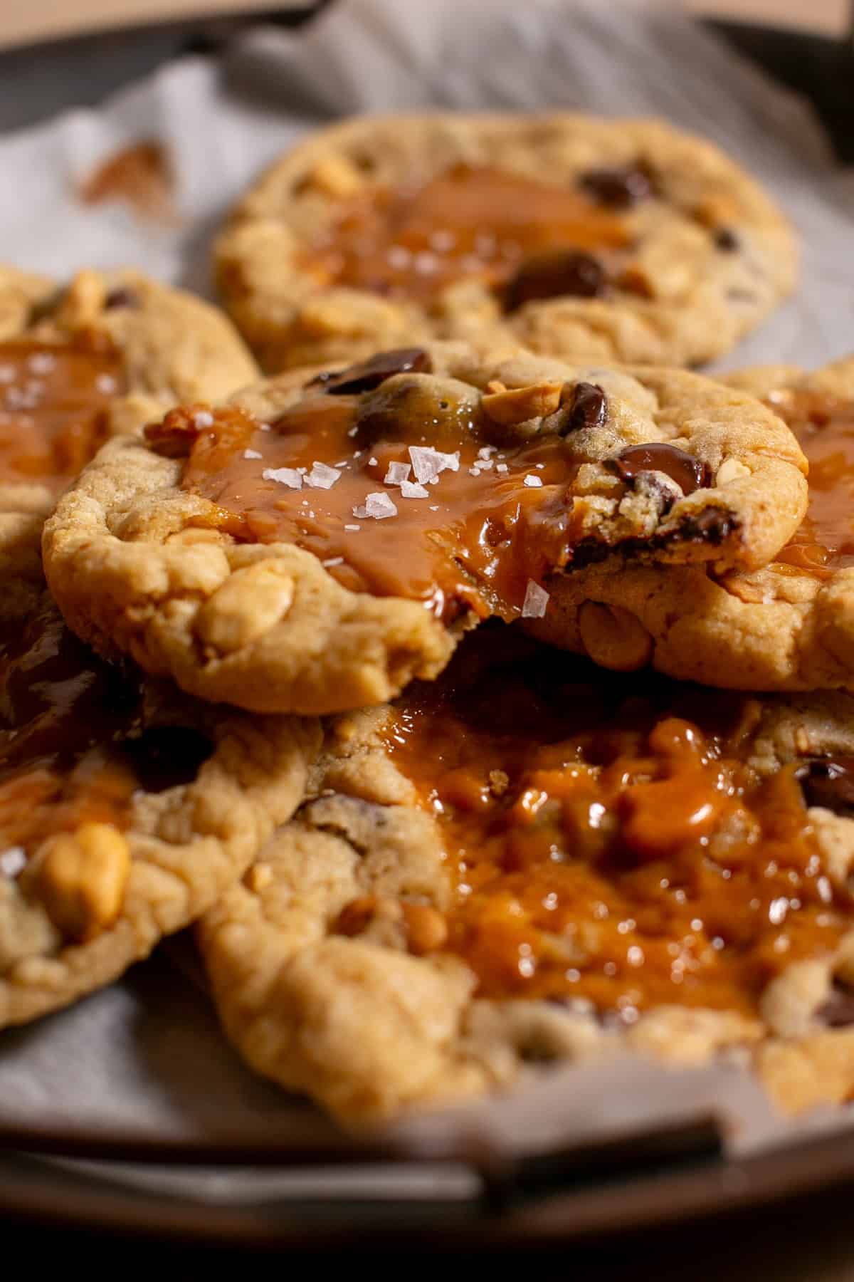 Snickers Cookies with a bite missing and gooey caramel dripping down.