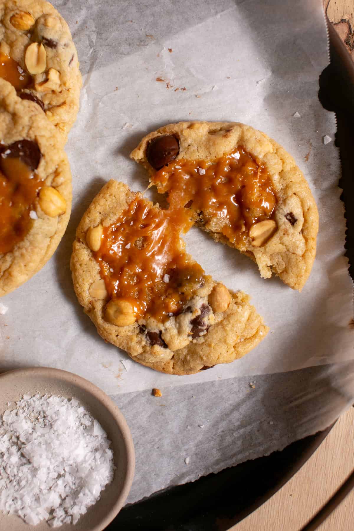 Snickers Cookie broken in half with caramel pulling in between.