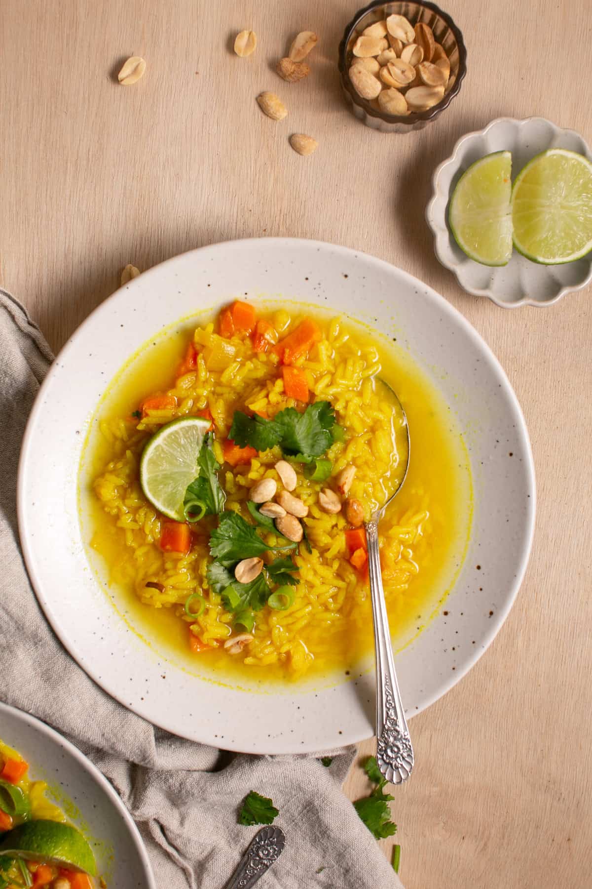 Feel-Good Turmeric Rice Soup by a bowl of lime wedges. 