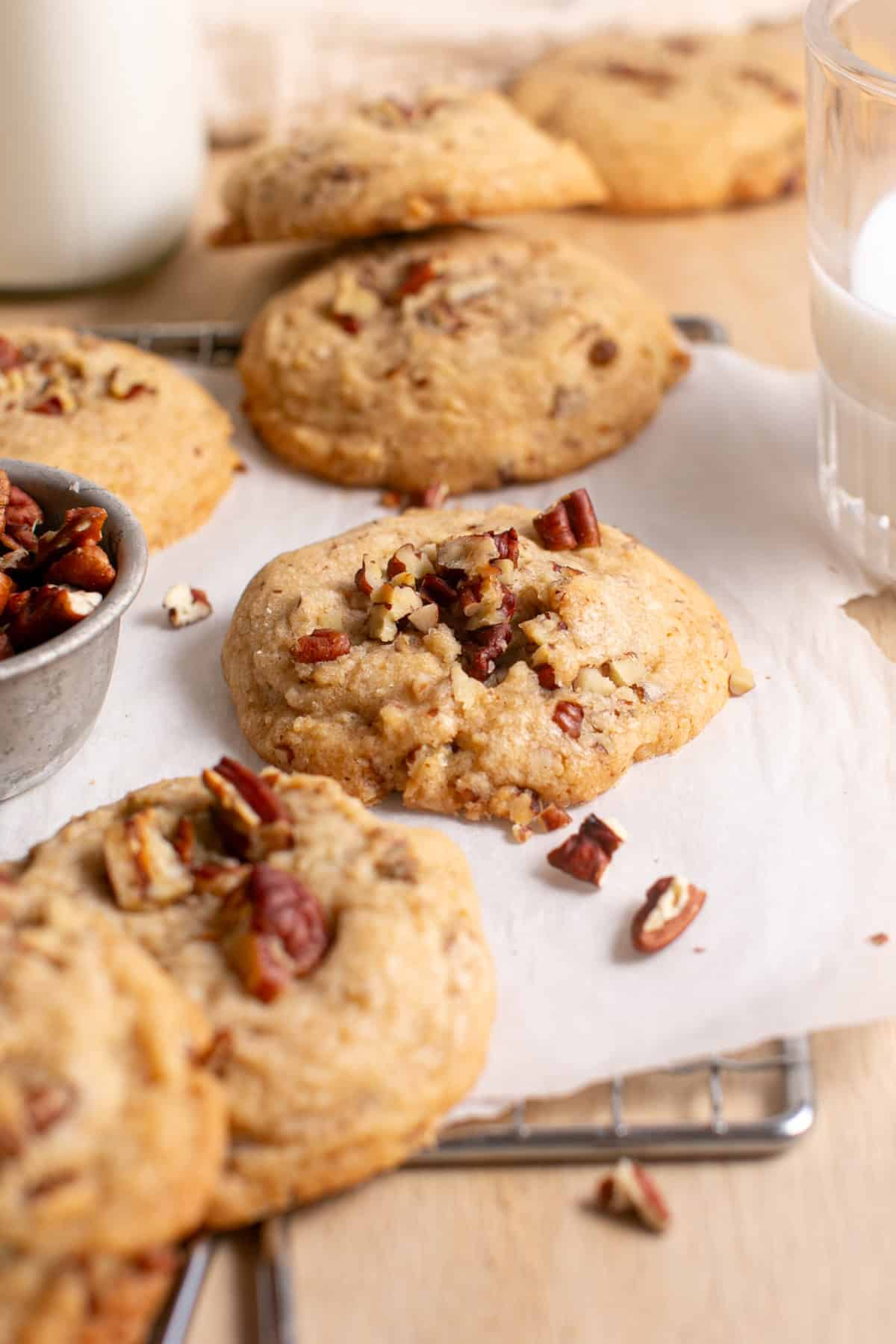 Browned Butter Pecan Cookies sitting by a glass of milk.