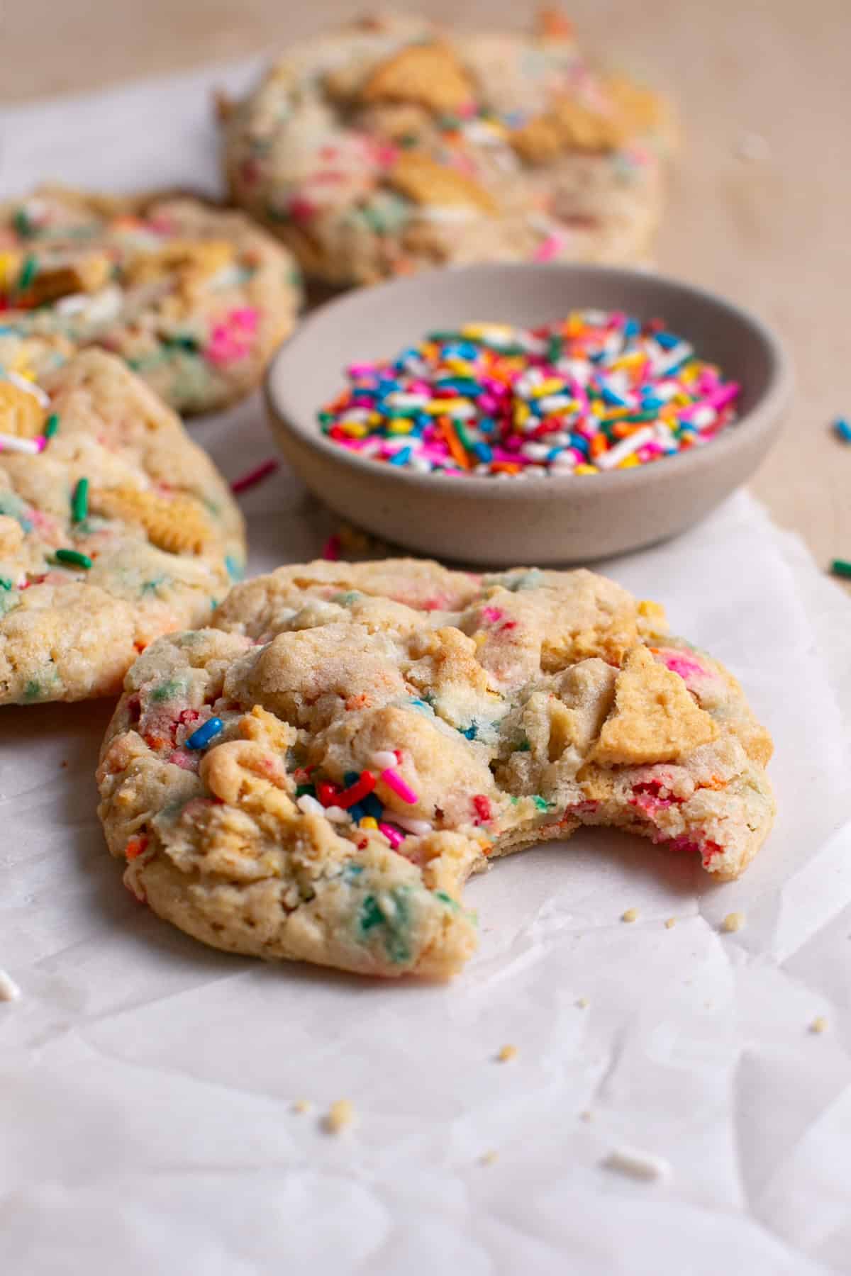 Golden Funfetti Cookies with a bite missing.