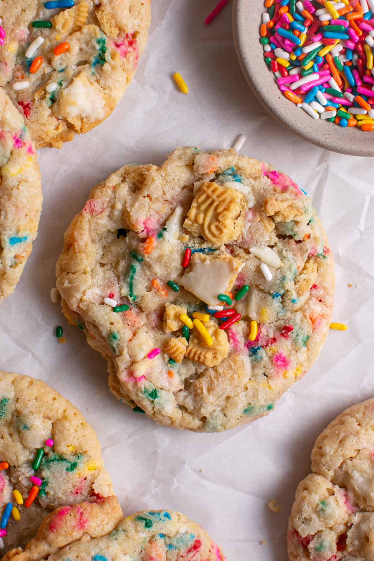 Golden Funfetti Cookies sitting by a bowl of sprinkles.