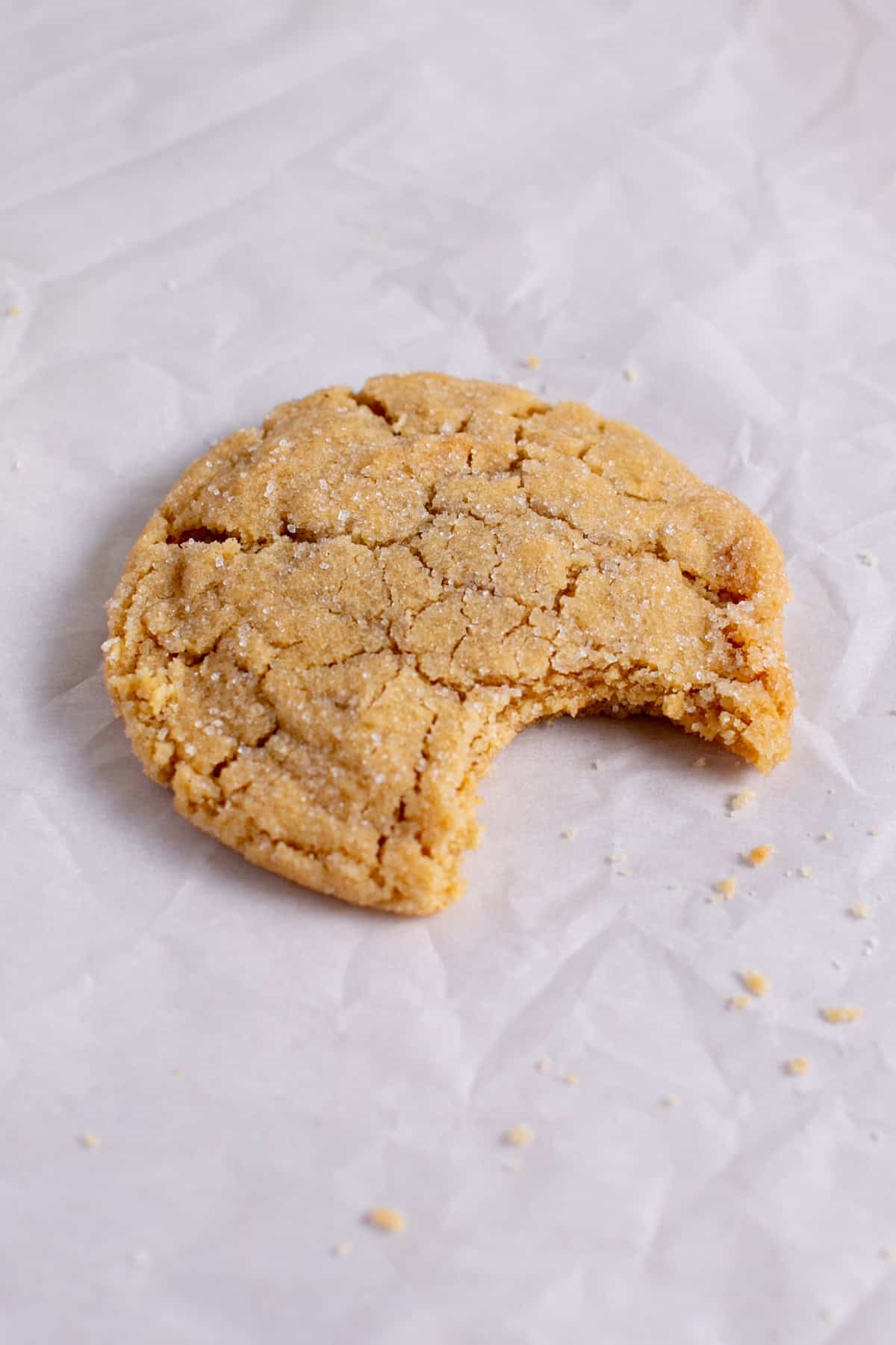 Single Serve Peanut Butter Cookie with a bite missing and some crumbs.