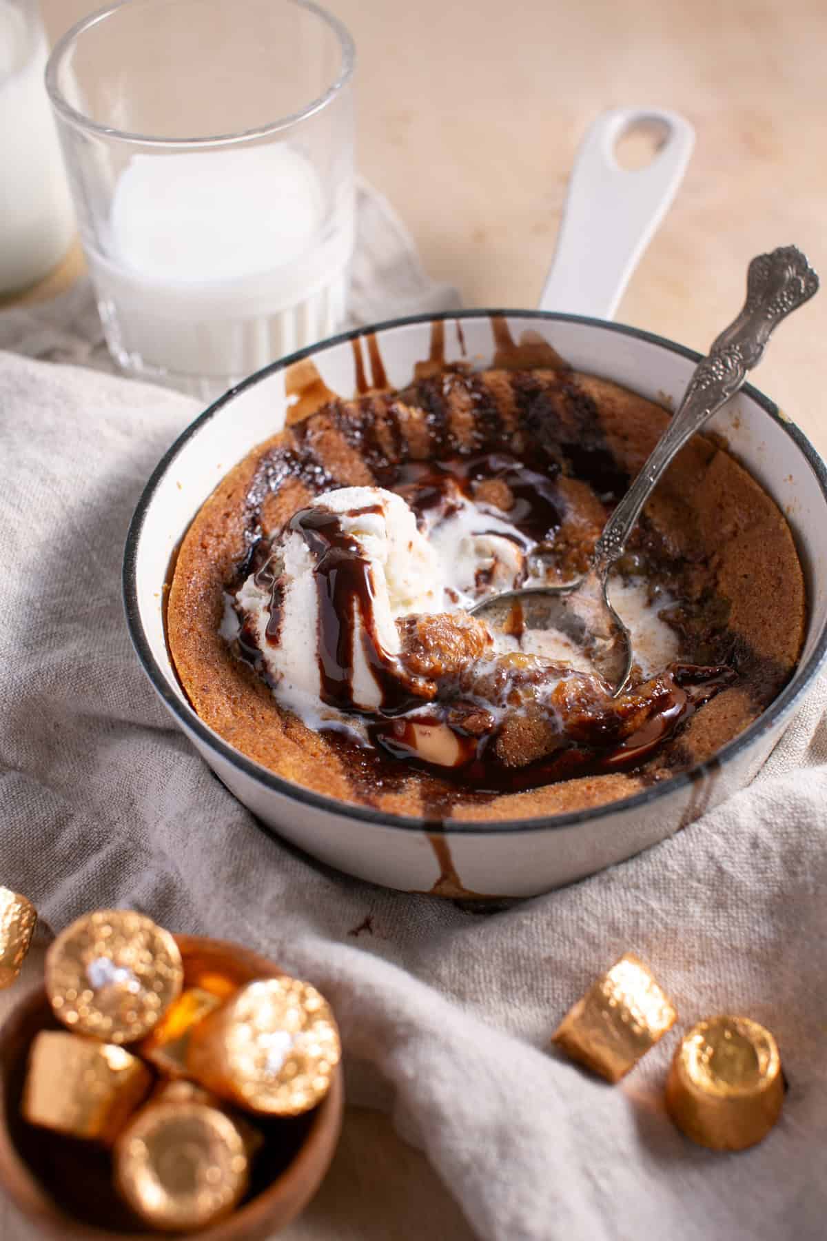 Skillet Chocolate Caramel Cookie with a scoop of ice cream and chocolate syrup. 