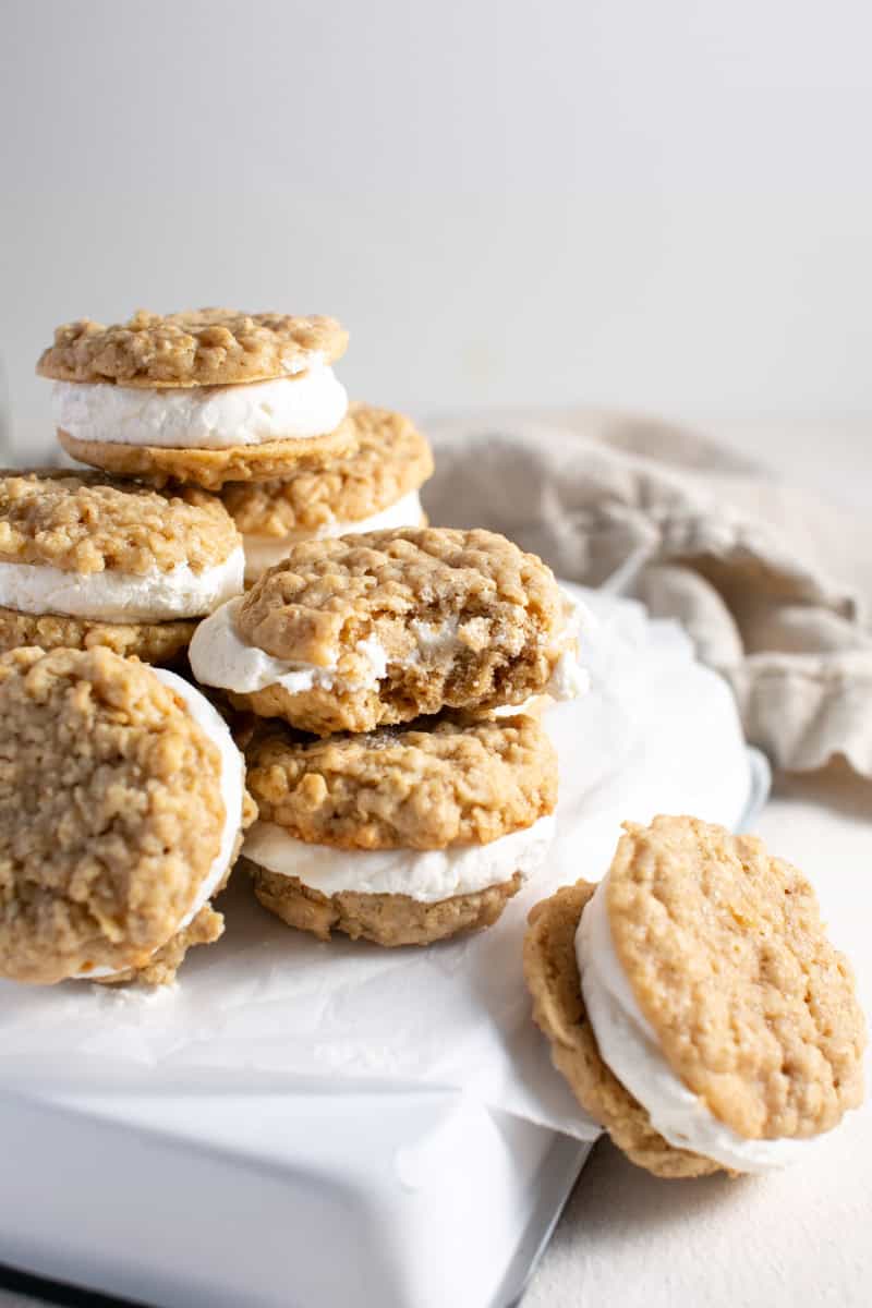 Ice cream sandwich cookies stacked on top of each other with a bite out of one. 