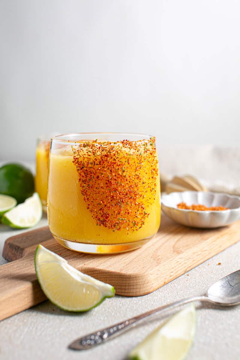 Mango Mocktail sitting on a cutting board with limes.