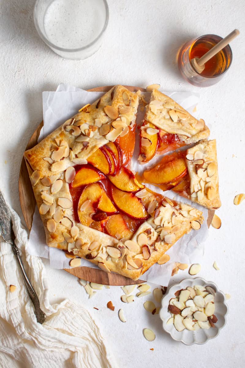 Sliced Peach Almond Galette on parchment paper. 