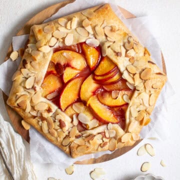 Peach galette on parchment paper.