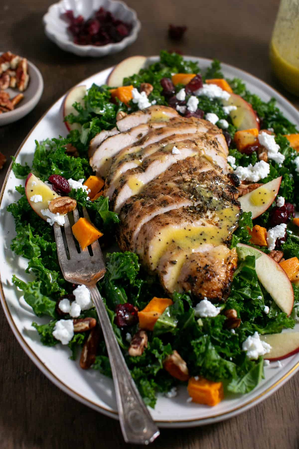 Sweet Potato Kale Salad with Honey Mustard Dressing with a serving platter and fork.