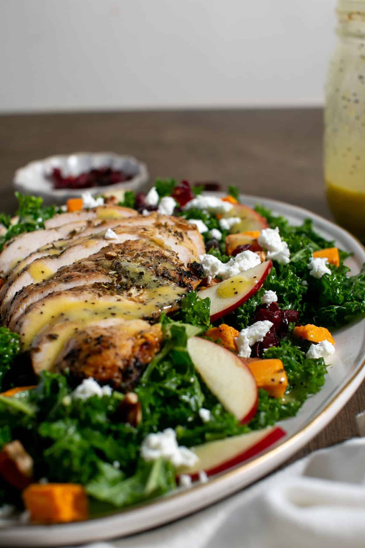 Sweet Potato Kale Salad with Honey Mustard Dressing with apple slices.