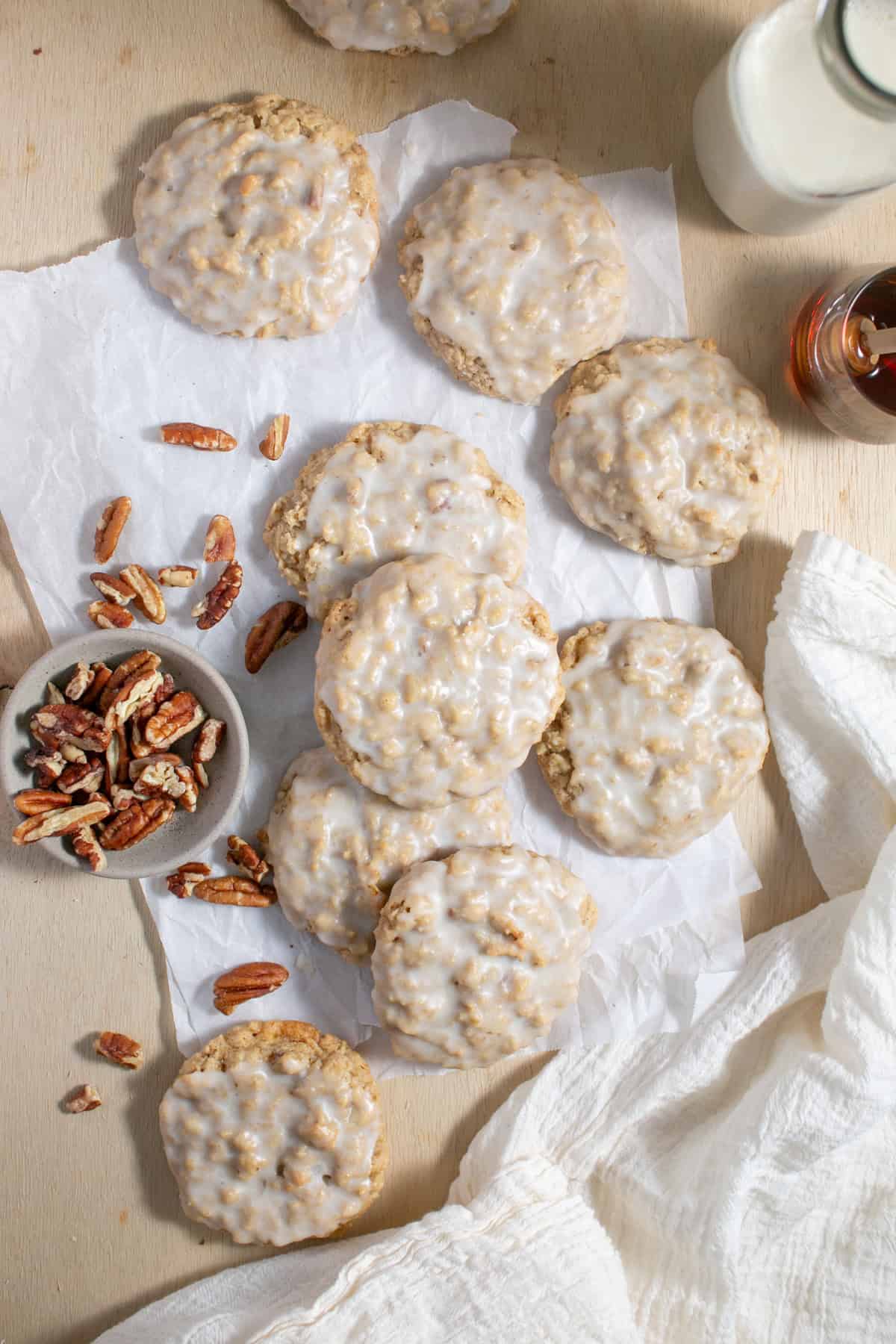 Maple Glazed Oatmeal Cookies sitting by a glass of milk.