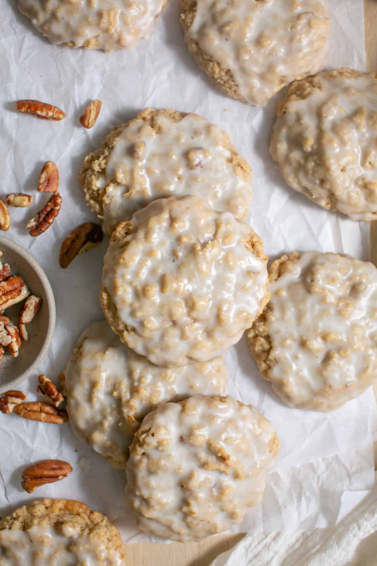 Maple Glazed Oatmeal Cookies sitting by some pecans. 