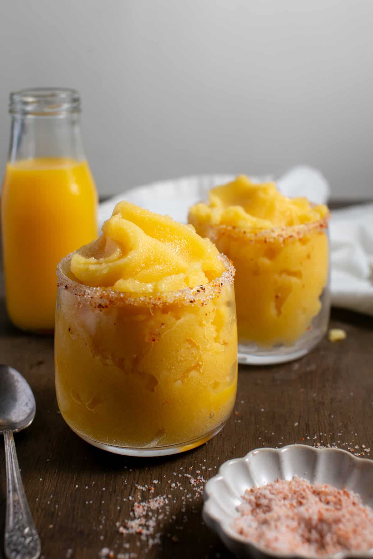 Rosé Peach Sorbet Cocktail sitting by a glass of orange juice. 