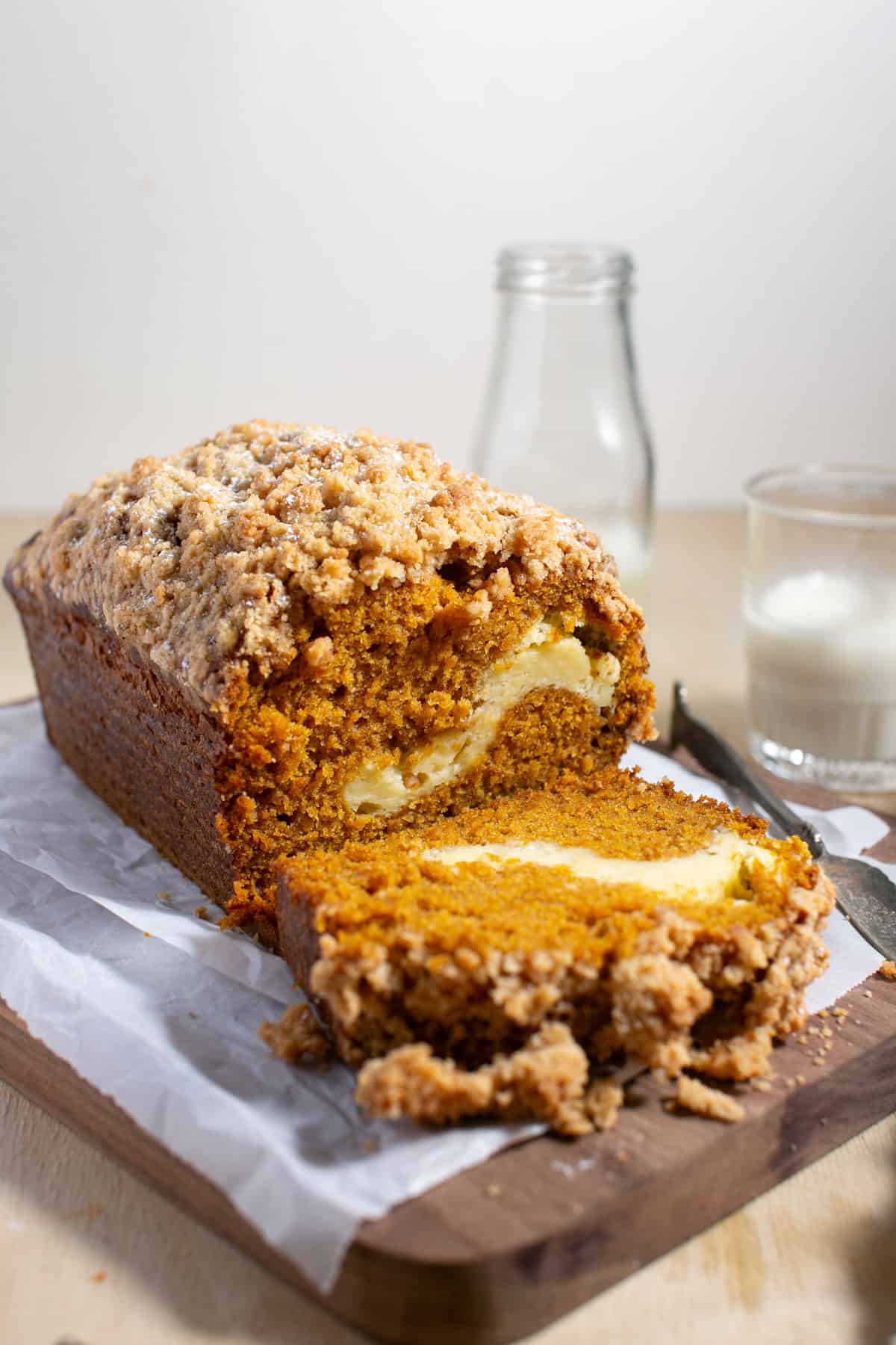 Cream Cheese Pumpkin Bread sitting by a glass of milk.