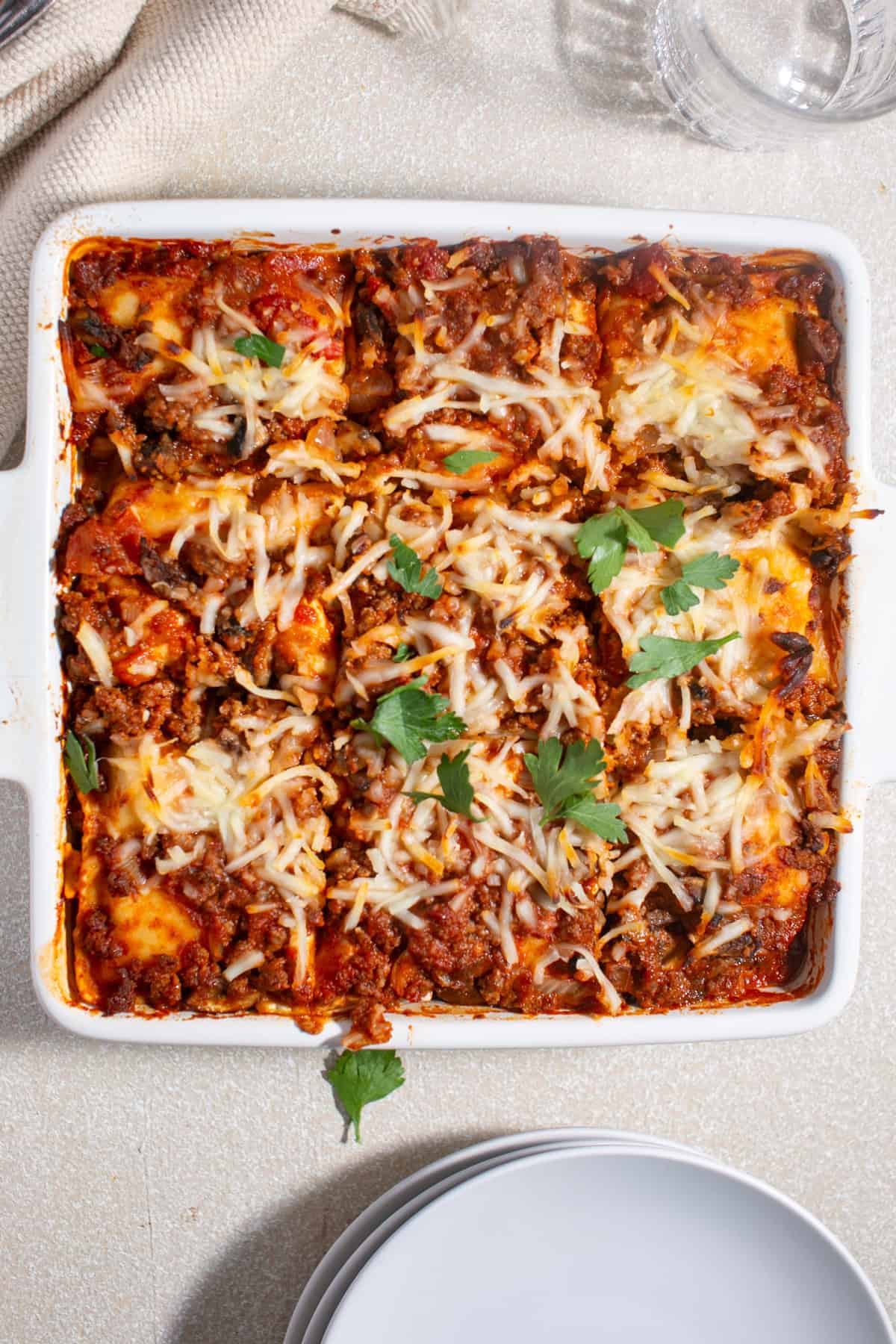 Ravioli Lasagna sitting by a glass of water.