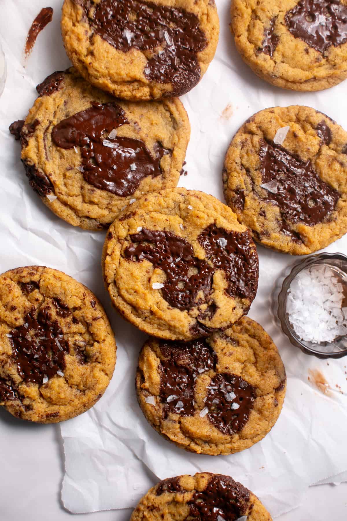 Thick and Chewy Pumpkin Dark Chocolate Chunk Cookies on parchment paper. 