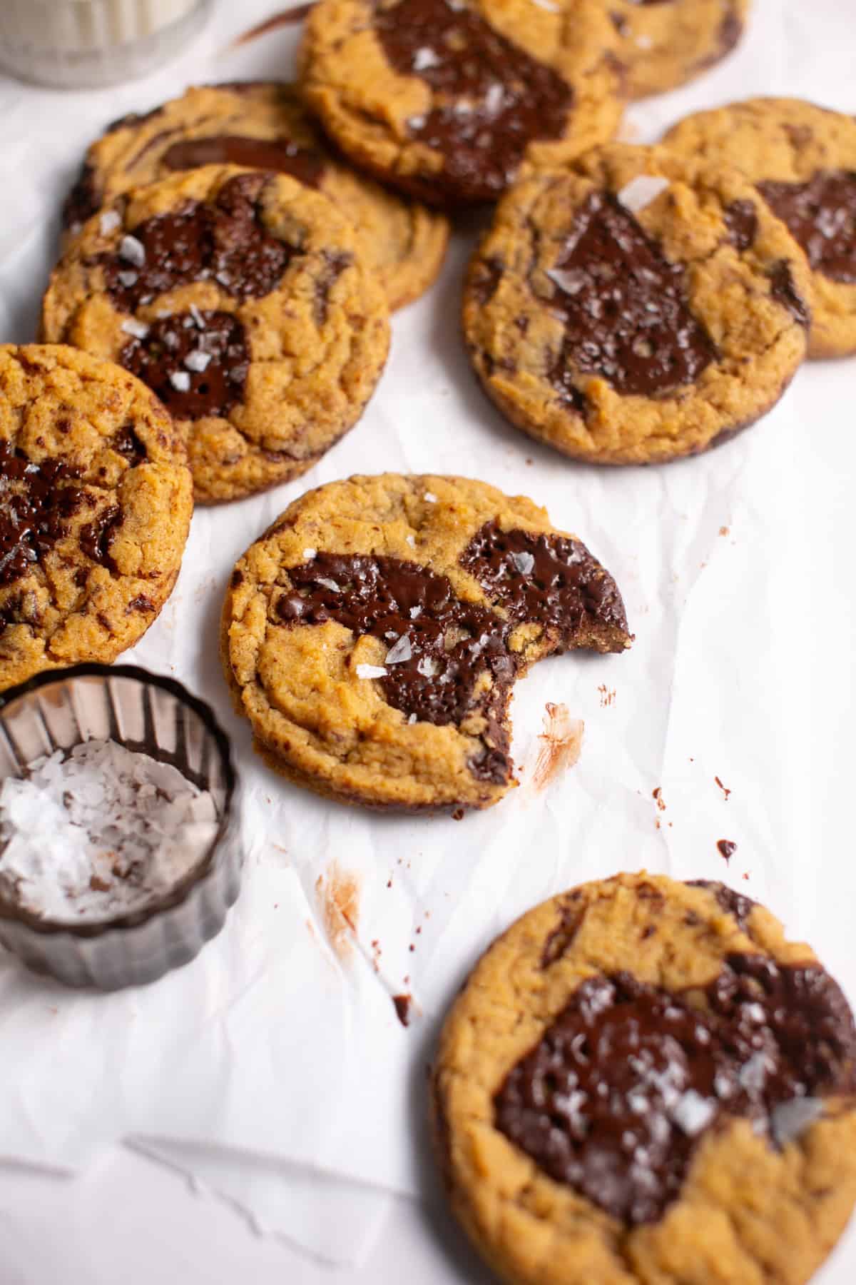 Thick and Chewy Pumpkin Dark Chocolate Chunk Cookies with a bite missing.