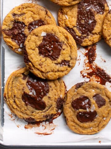 Thick and Chewy Pumpkin Dark Chocolate Chunk Cookies on a sheet pan.