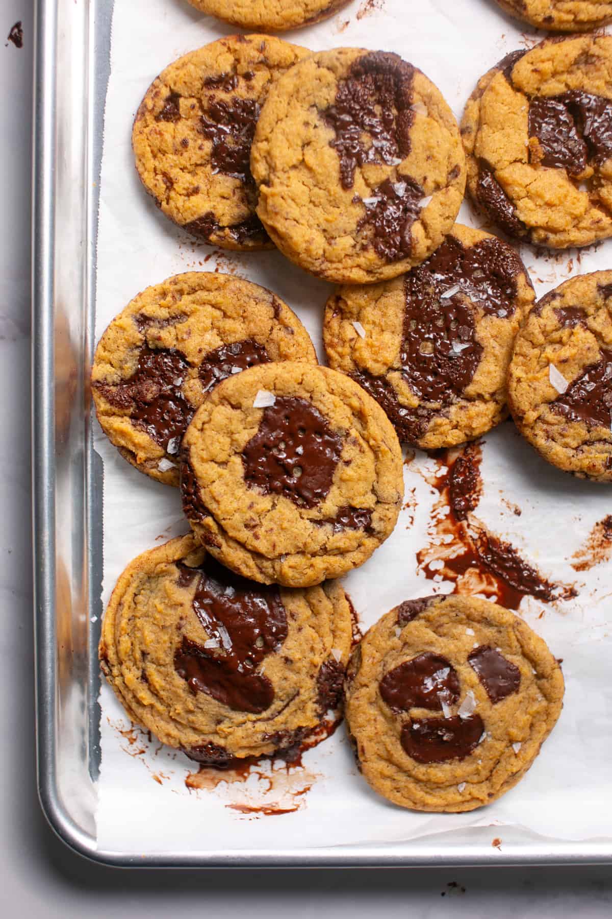 Thick and Chewy Pumpkin Dark Chocolate Chunk Cookies on a sheet pan. 