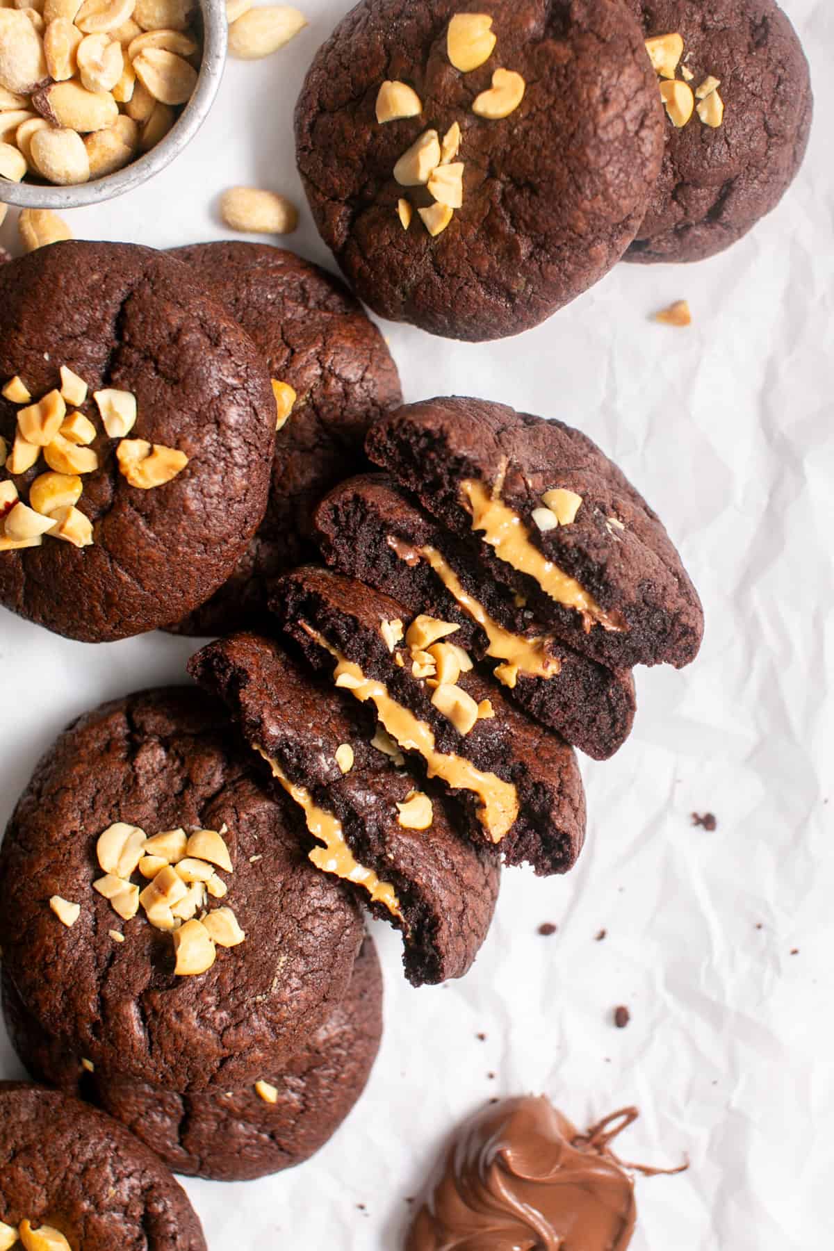 Peanut Butter Nutella Stuffed Cookie broken in half on parchment paper. 