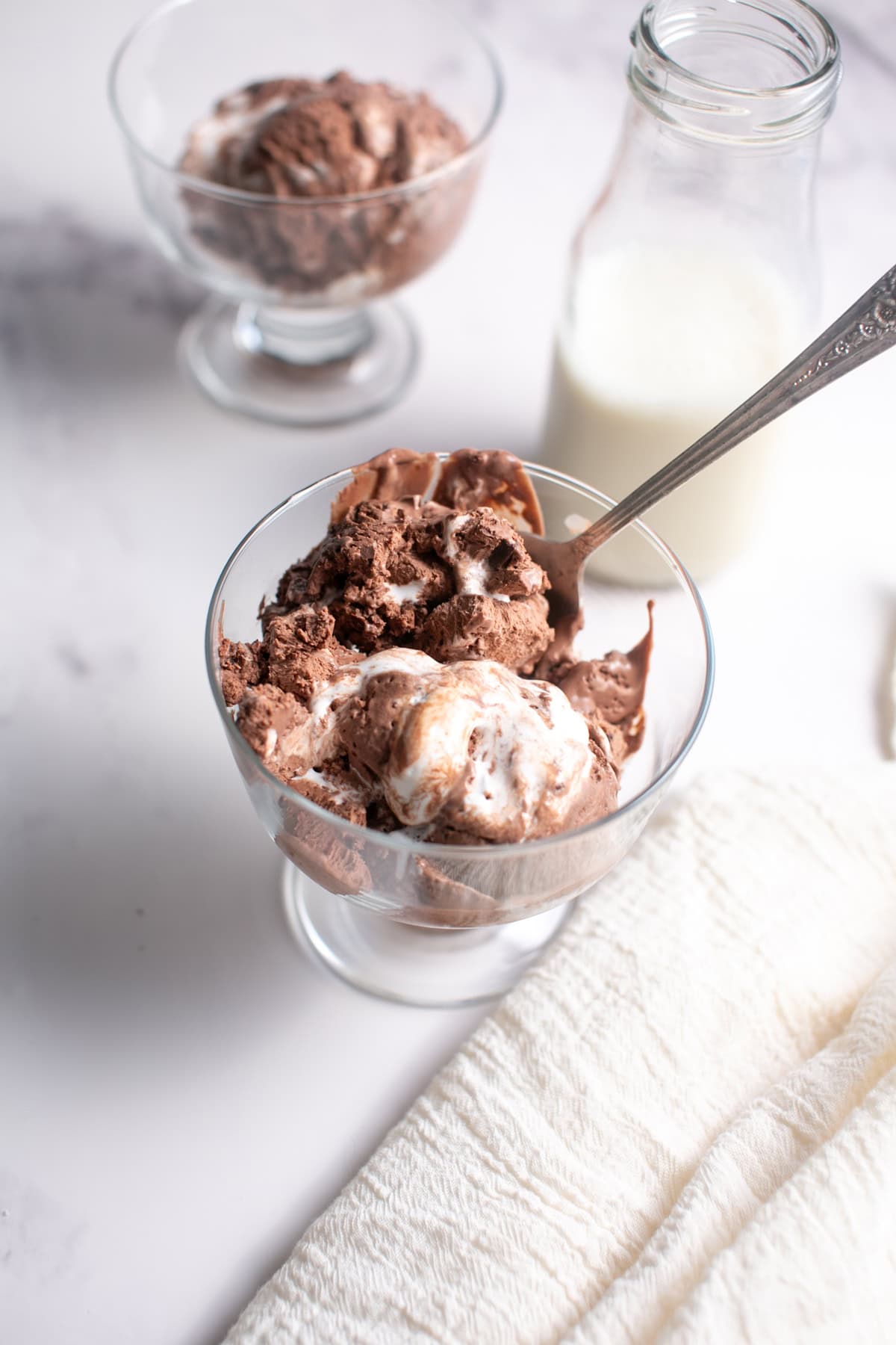 Single Serve Dark Chocolate Marshmallow Ice Cream sitting by a glass of milk.