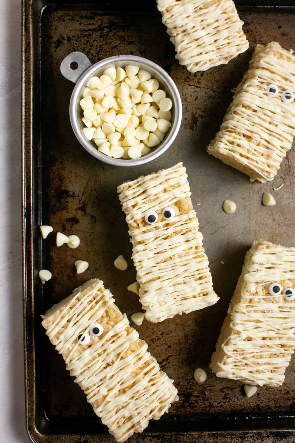 White Chocolate Mummy bars sitting by a bowl of white chocolate chips.