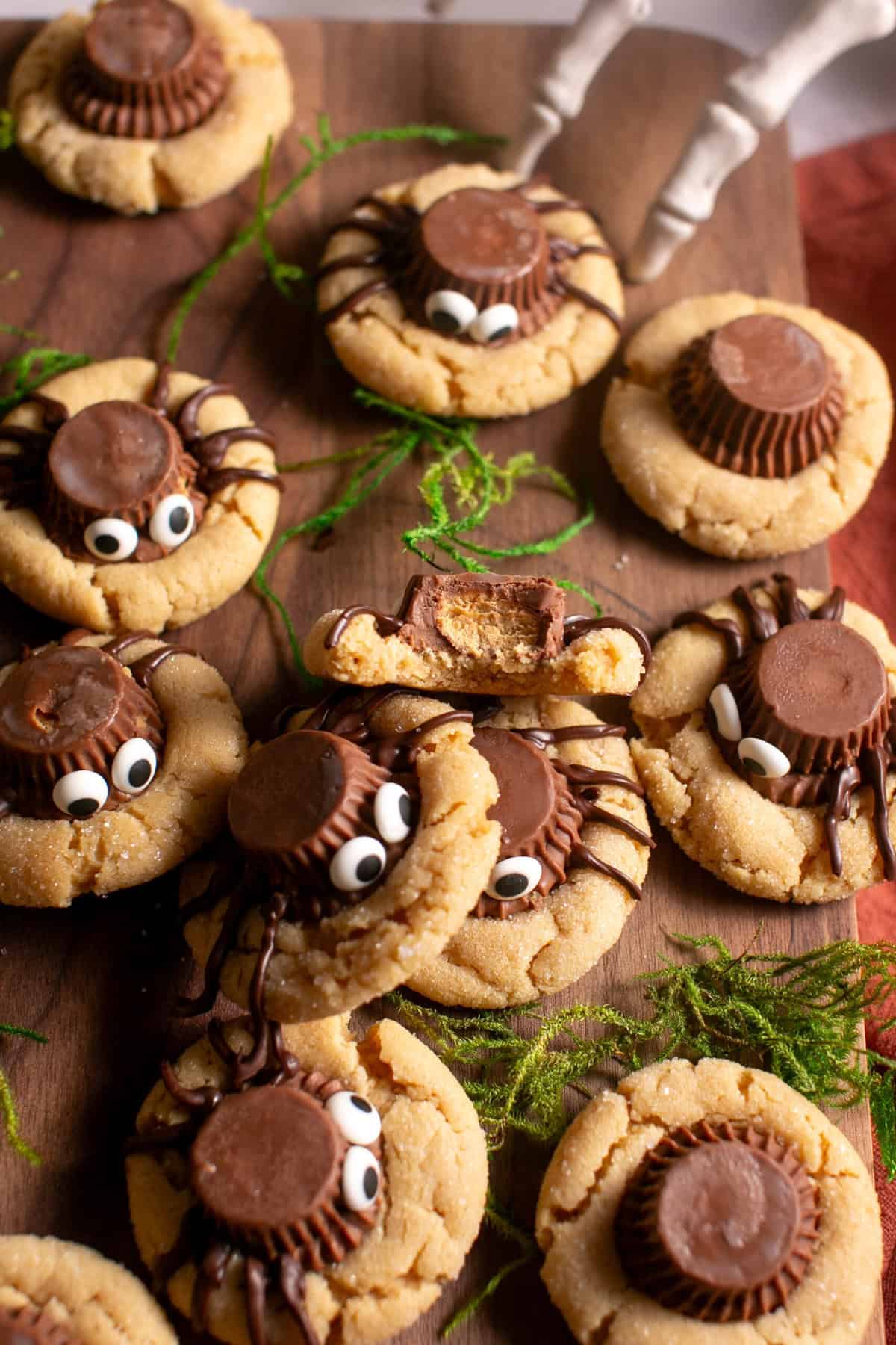 Peanut butter blossom spider cookies on a cutting board.