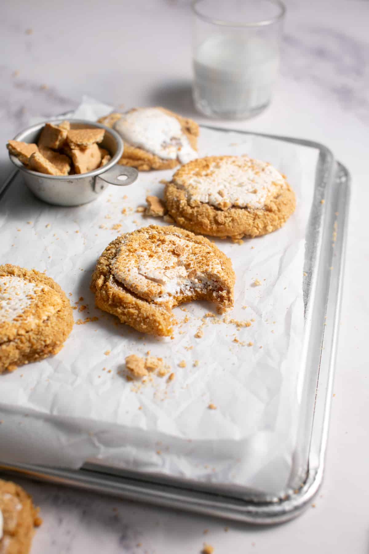 Marshmallow Fluff Cookies with a bite missing on a sheet tray.