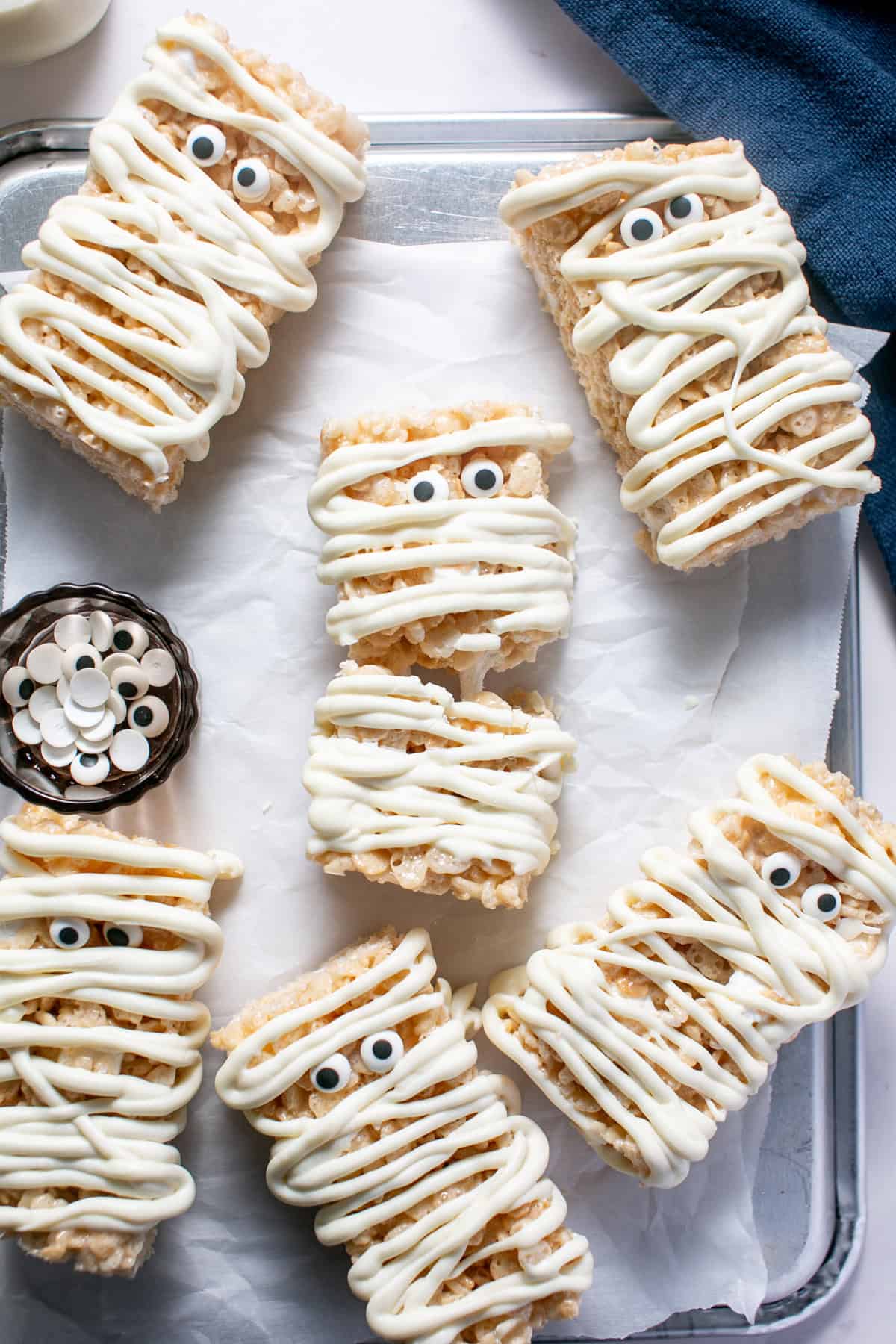 Halloween Mummy Rice Krispie Treats broken in half with a marshmallow pull. 