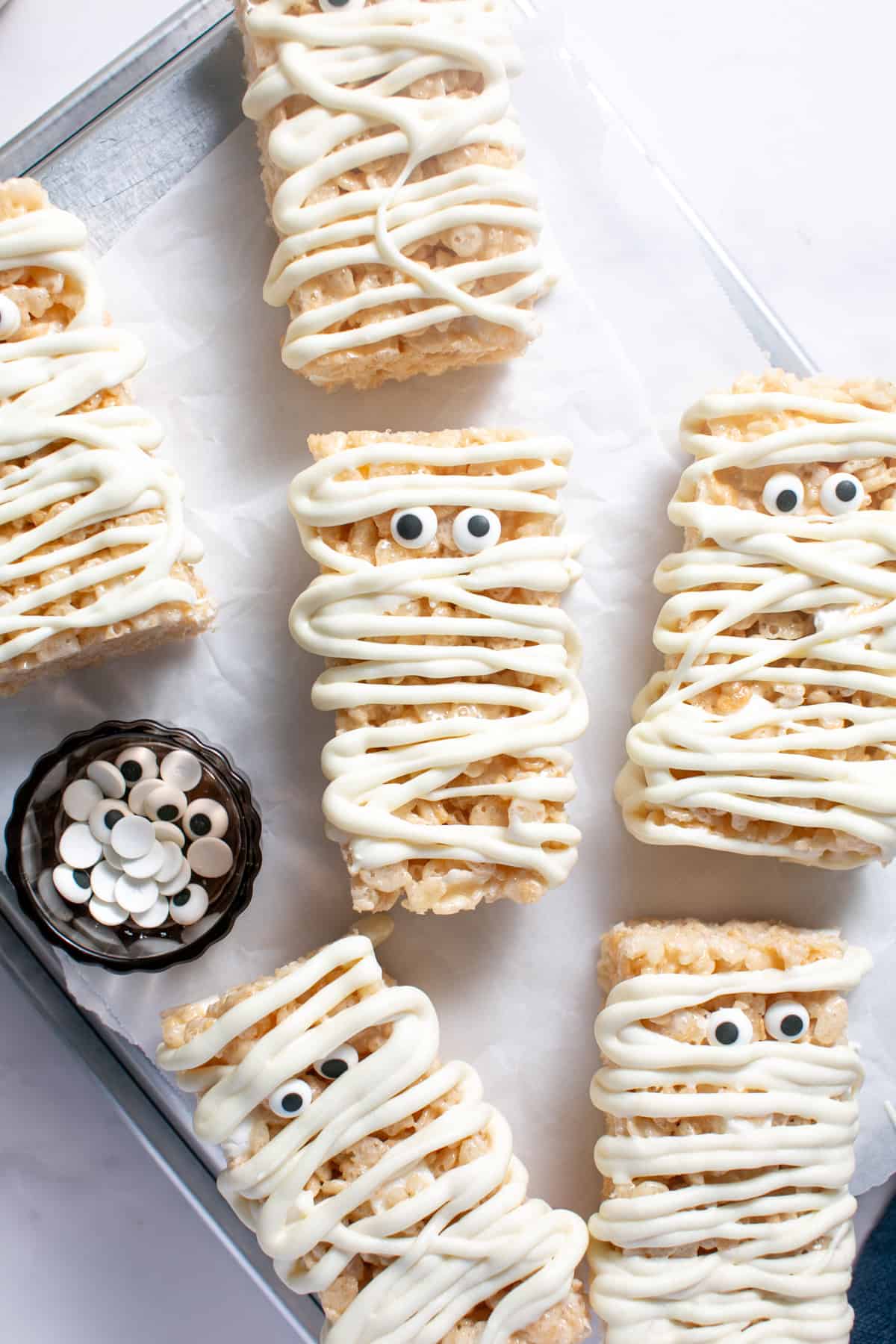 Halloween Mummy Rice Krispie Treats on a baking sheet. 